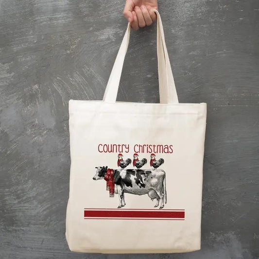 a person holding a tote bag with cows on it