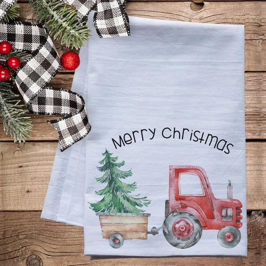 a christmas tea towel with a tractor and a christmas tree on it