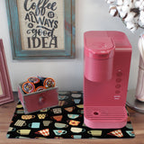 a pink coffee maker sitting on top of a table